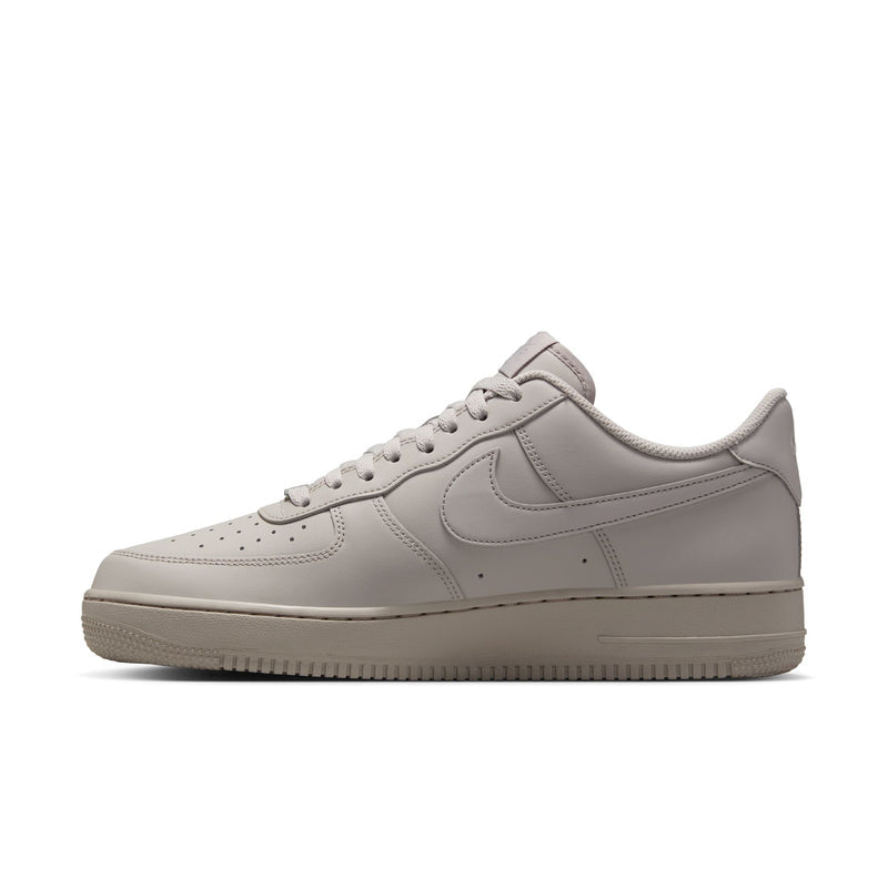 Light gray Nike low-top sneakers with lace-up closure and textured rubber sole