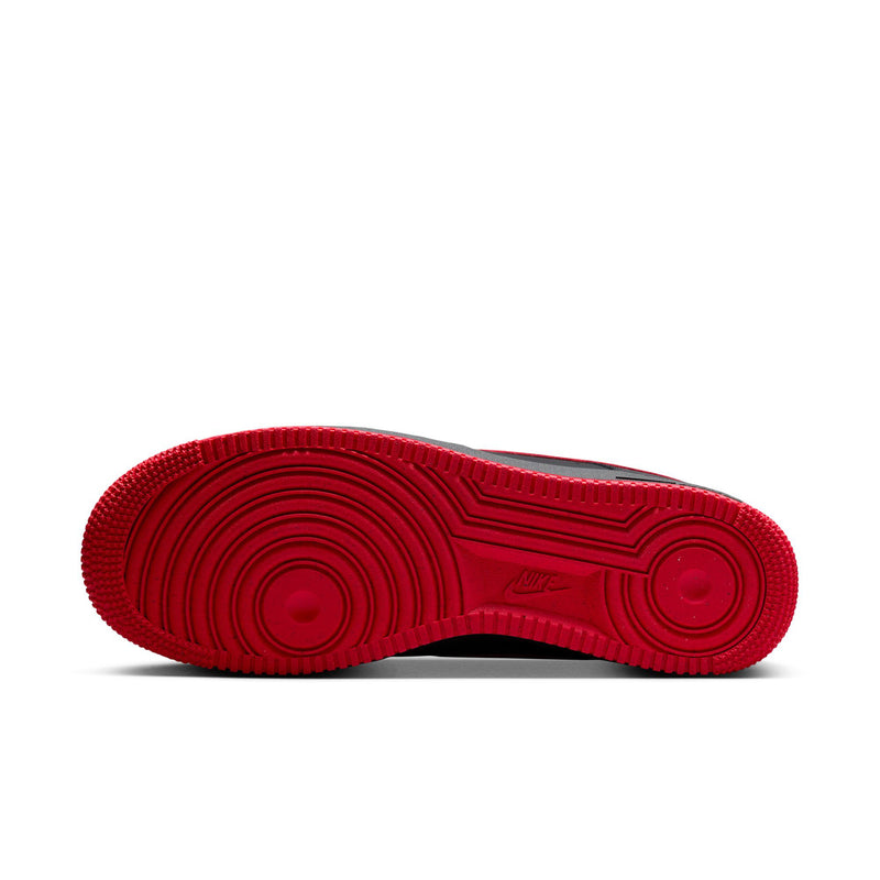 Red rubber outsole of black Nike low-top sneaker with traction tread