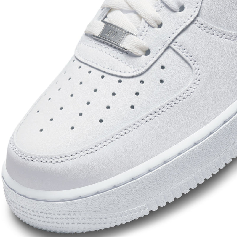 Close-up of white perforated toe and lace-up eyelets with metal lace tag