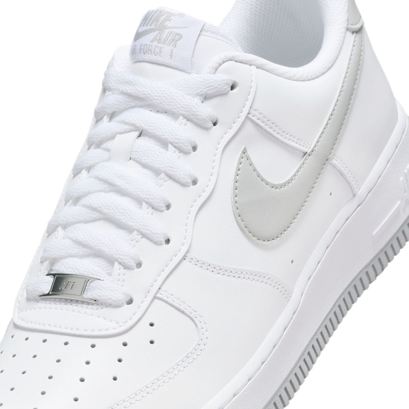 Close-up of men's white low-top sneakers with Nike Air insole and lace-up stitching