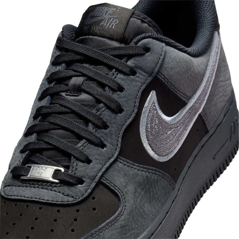 Men's low-top sneaker upper in black and smoke gray, close-up of laces and Swoosh