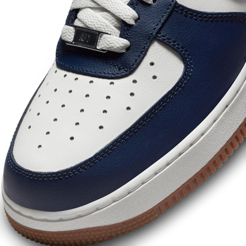 Close-up of navy and white leather sneaker with perforations and lace eyelets