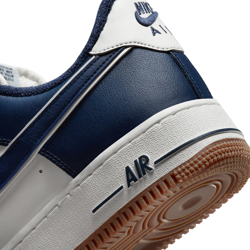 Close-up of sneaker midsole and outsole, navy upper with Air logo and gum tread