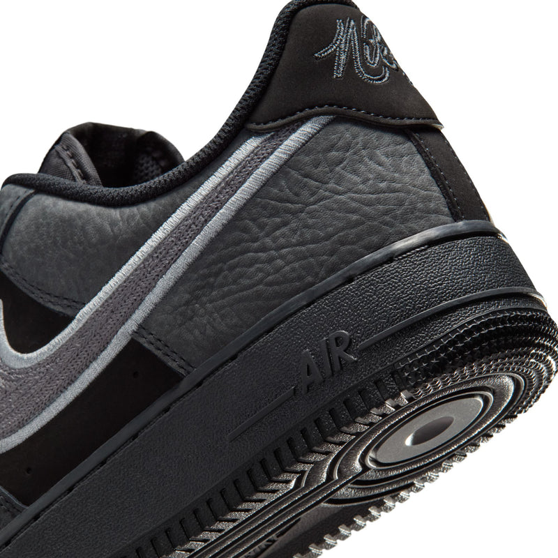 Men's low-top sneakers close-up: black sole with Air window and textured heel panel