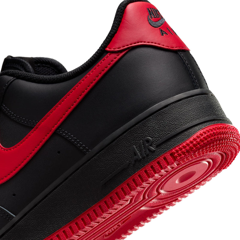 Black Nike low-top sneaker close-up of red outsole and AIR midsole text