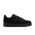 Black low-top sneakers with textured upper, lace-up front, and black rubber sole