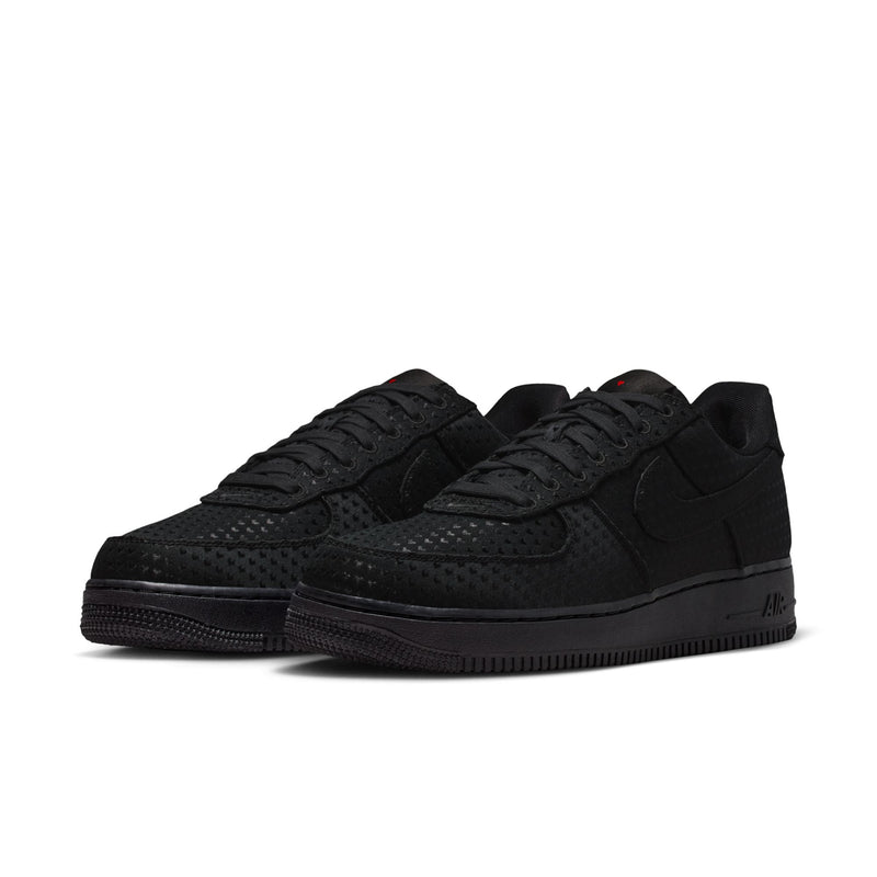Pair of black low-top sneakers with perforated look, lace-up design, and thick sole