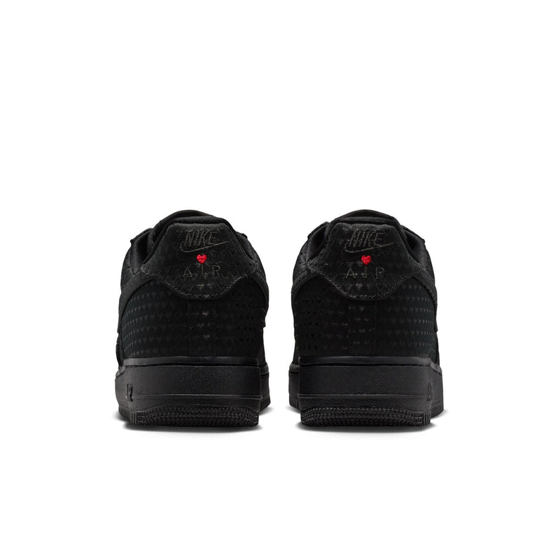 Black low-top sneakers with rear heel tabs and small red detail on each shoe