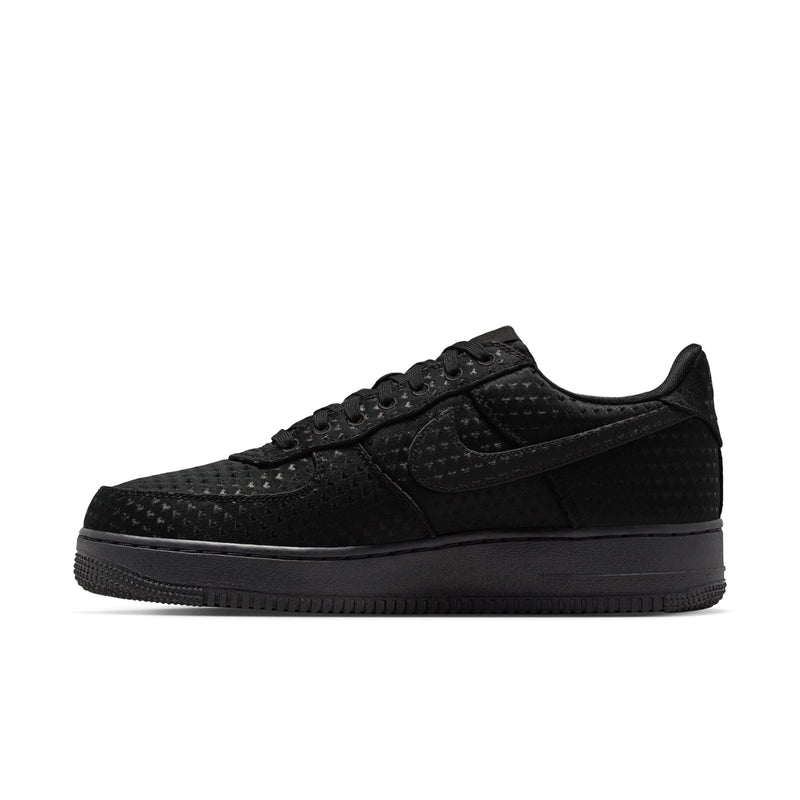Black low-top sneakers side view with lace-up closure, textured panels, and dark sole