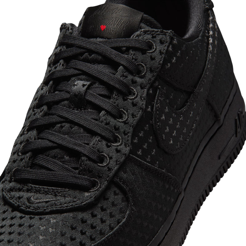 Close-up of black low-top sneaker laces and textured upper near the tongue