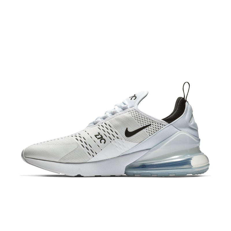 White and black low-cut sneakers with perforated upper, Nike swoosh, and blue Air sole