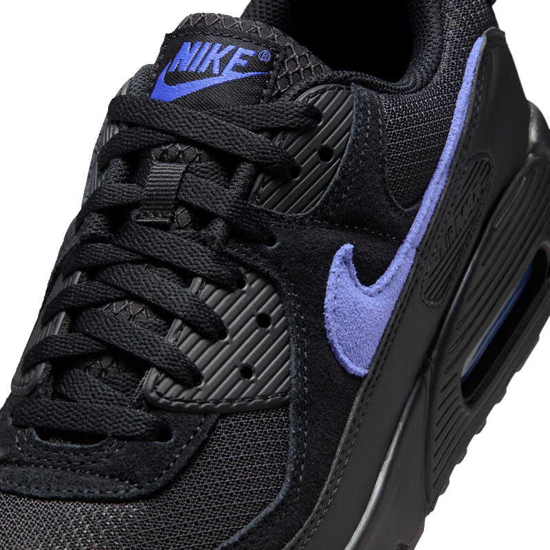 Close-up of black sneaker upper with blue swoosh and textured lacing panels