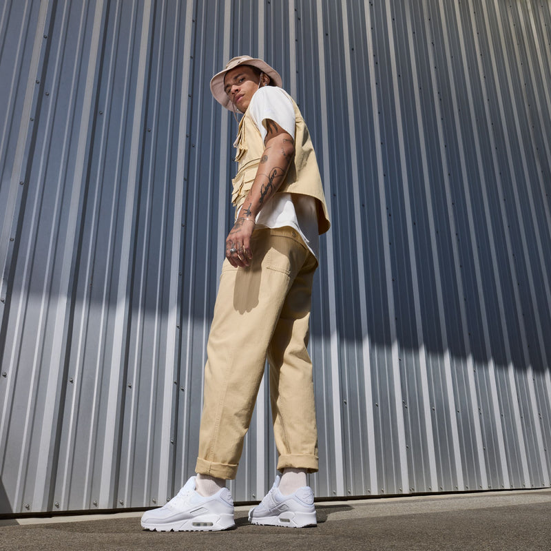 White lace-up sneakers on feet with low-profile air-cushion midsole