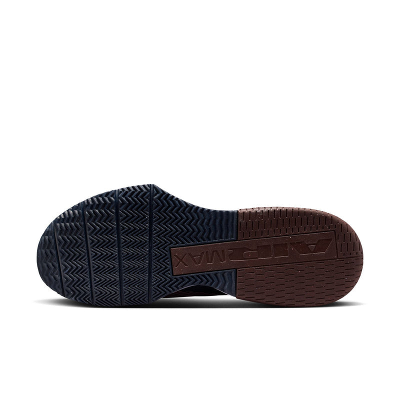 Shoe outsole showing dark traction tread and burgundy heel plate detail.