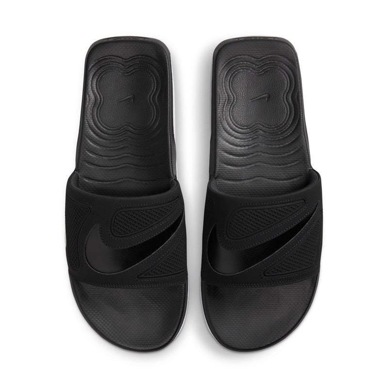 Black Nike slide sandals, front view with embossed tread pattern on footbed