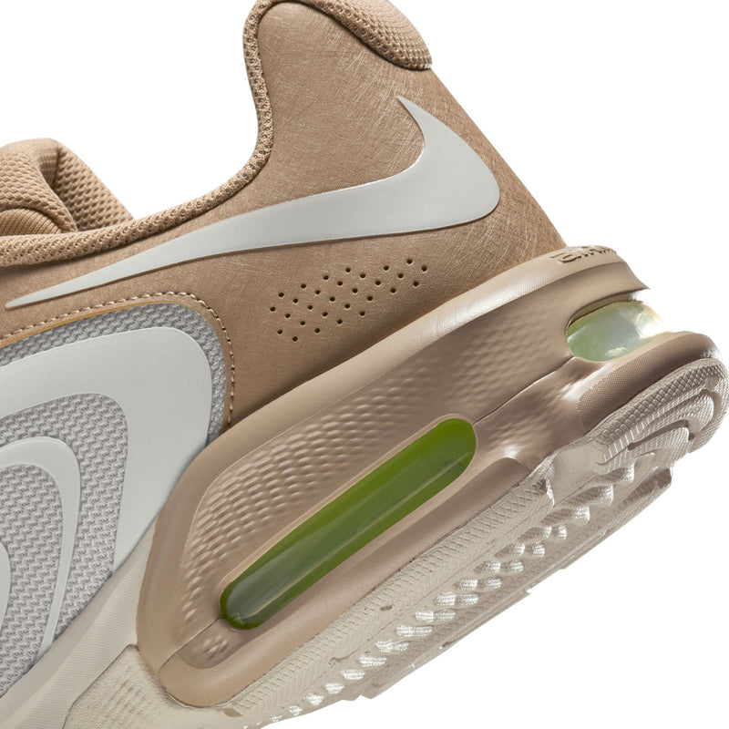 Close-up men's tan sneakers with neon green Air window and perforated toe panel