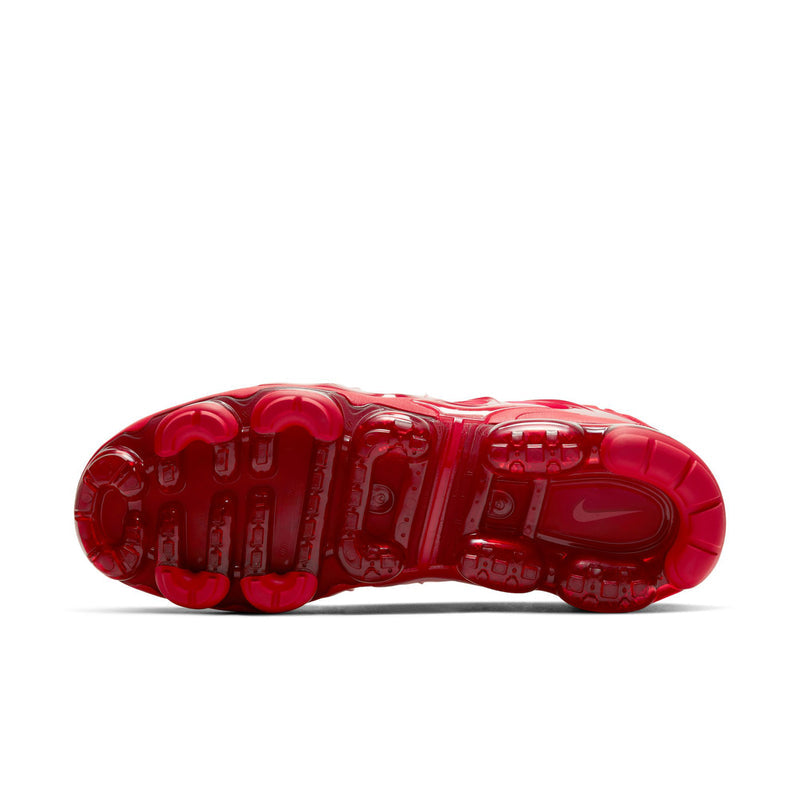 Red molded traction outsole for men's running shoe with circular stud pattern.