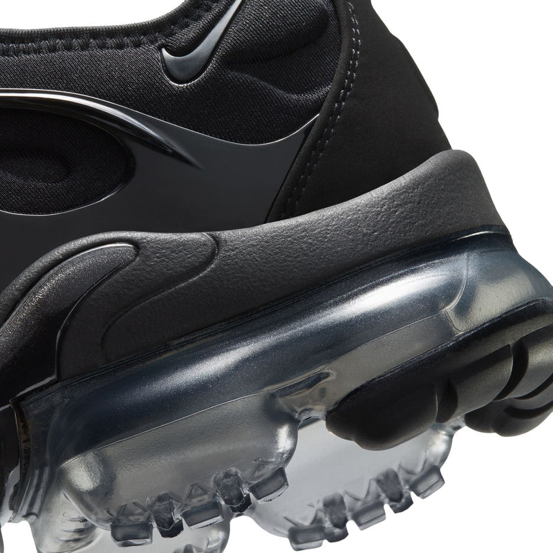 Black sneaker midsole close-up with clear air pods and contoured rubber traction pods.