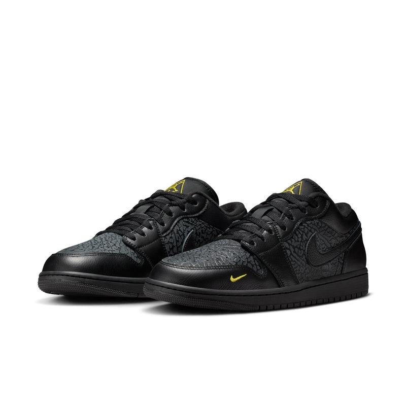 Pair of black low-top sneakers with yellow detailing, lace-up front view