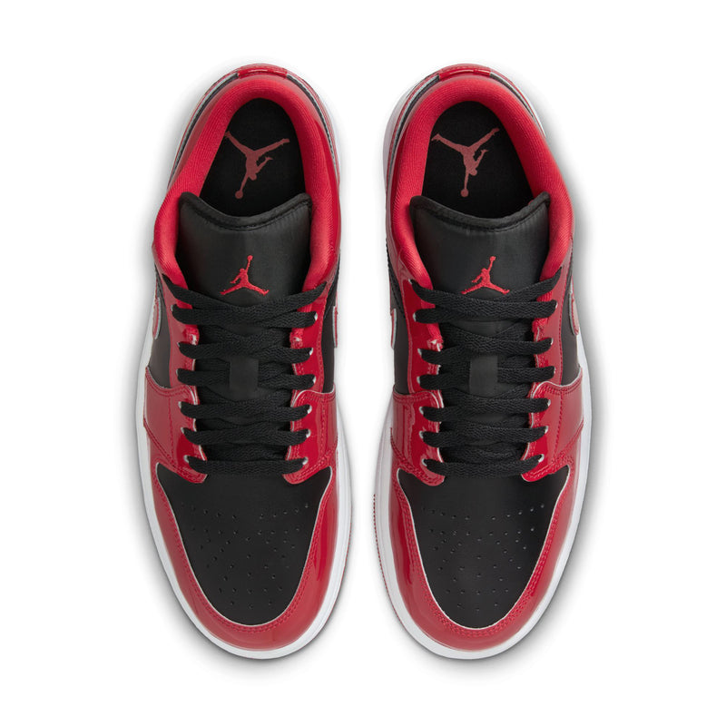 Men's low-top sneakers viewed from the front with red tongues and black lace-up panels.