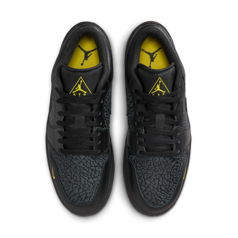 Black low-top sneakers, top view of laces and textured toe with yellow lining