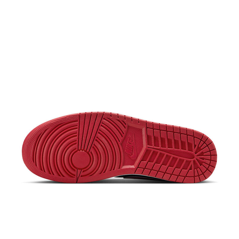 Red outsole tread of men's low-top sneakers with grid-pattern traction.