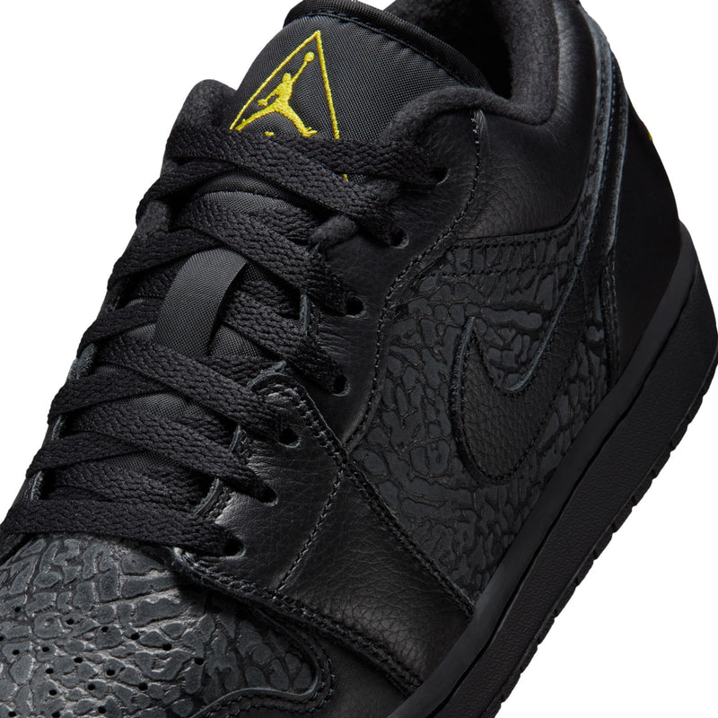 Close-up of black leather low-top sneakers with yellow Jumpman embroidery