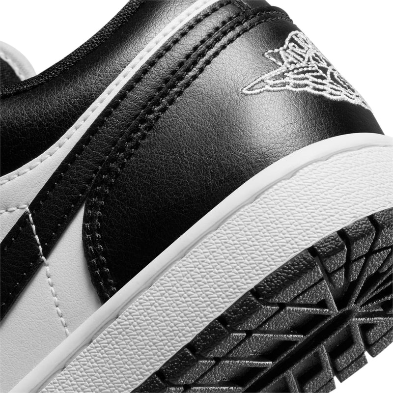 Black and white leather sneaker with stitched seam, wing logo, and outsole edge