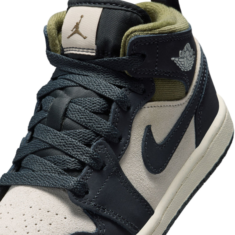 Kids' mid-top sneakers close-up, black laces with cream panels and olive collar