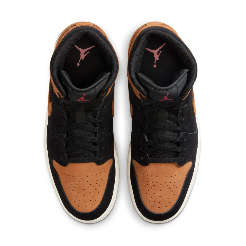 Black and tan mid-top sneakers with perforated toe and pink logo on tongue