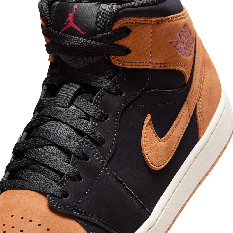 Close-up of black and tan mid-top sneaker with black laces and tan swoosh