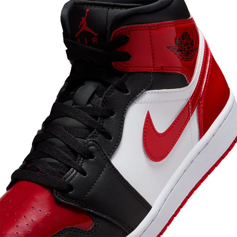 Air Jordan 1 Mid SE lace-up close-up with red tongue and white swoosh on black