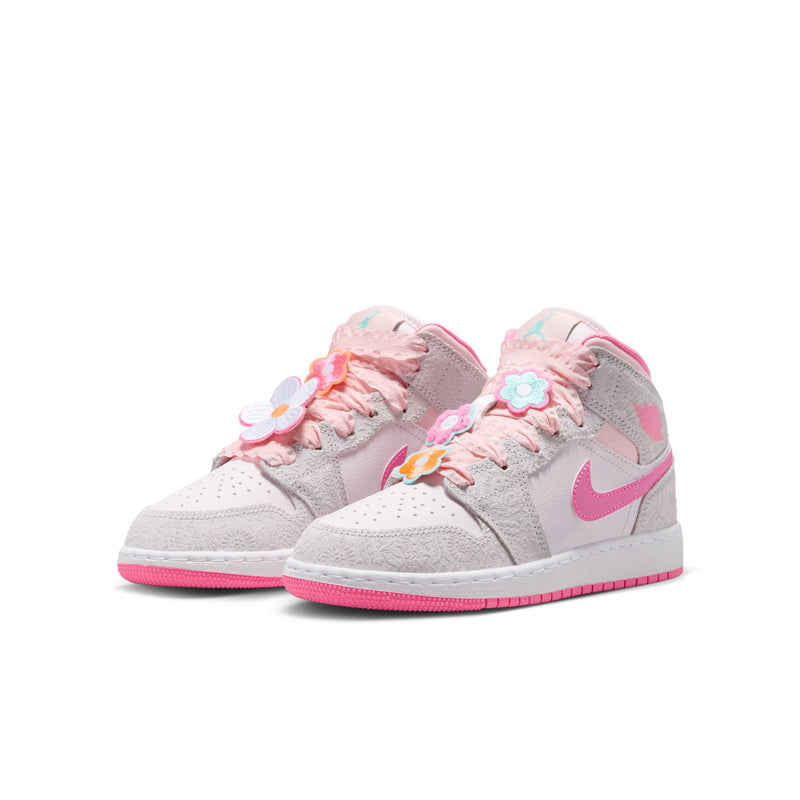 Youth mid-top sneakers pair view with colorful flower appliques and pink outsole trim.