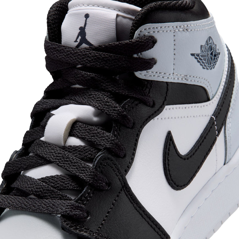 Youth high-top sneaker close-up, black laces and tongue patch, black and light gray panels
