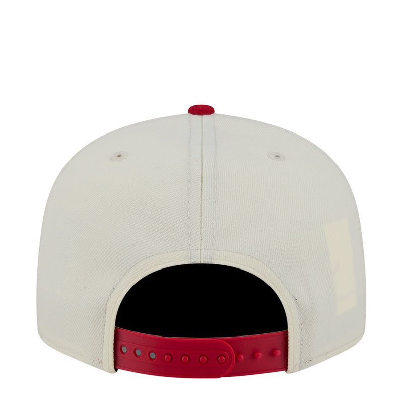 Two-tone baseball cap with white crown and red snapback strap, open back