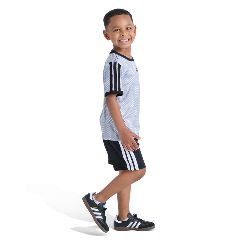 Kids soccer set side view: light blue patterned jersey with black stripes and black shorts