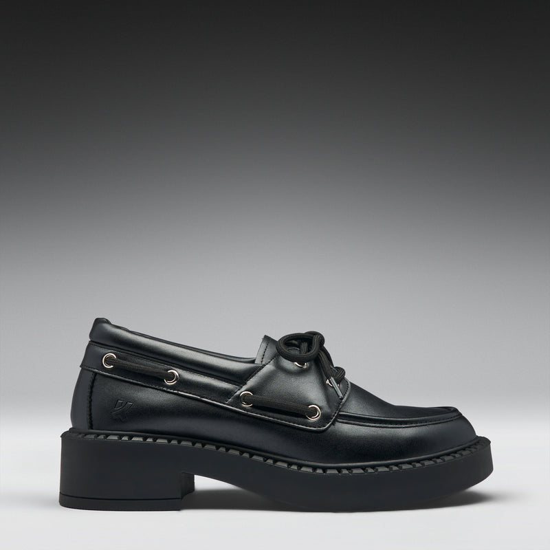 Black leather boat shoe on a gradient gray background