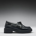 Black leather boat shoe on a gradient gray background