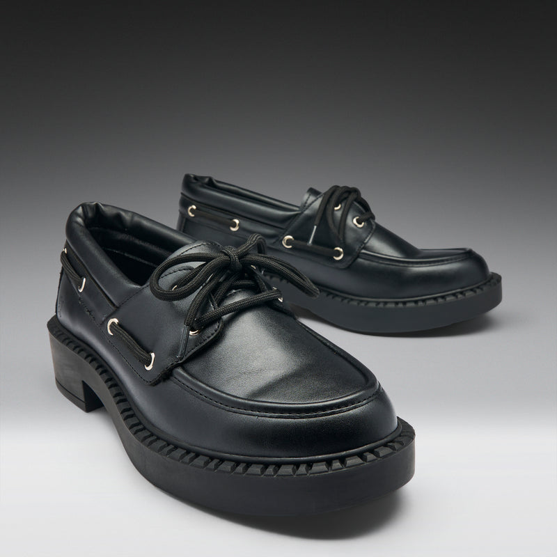 Pair of black leather shoes on a gradient gray background