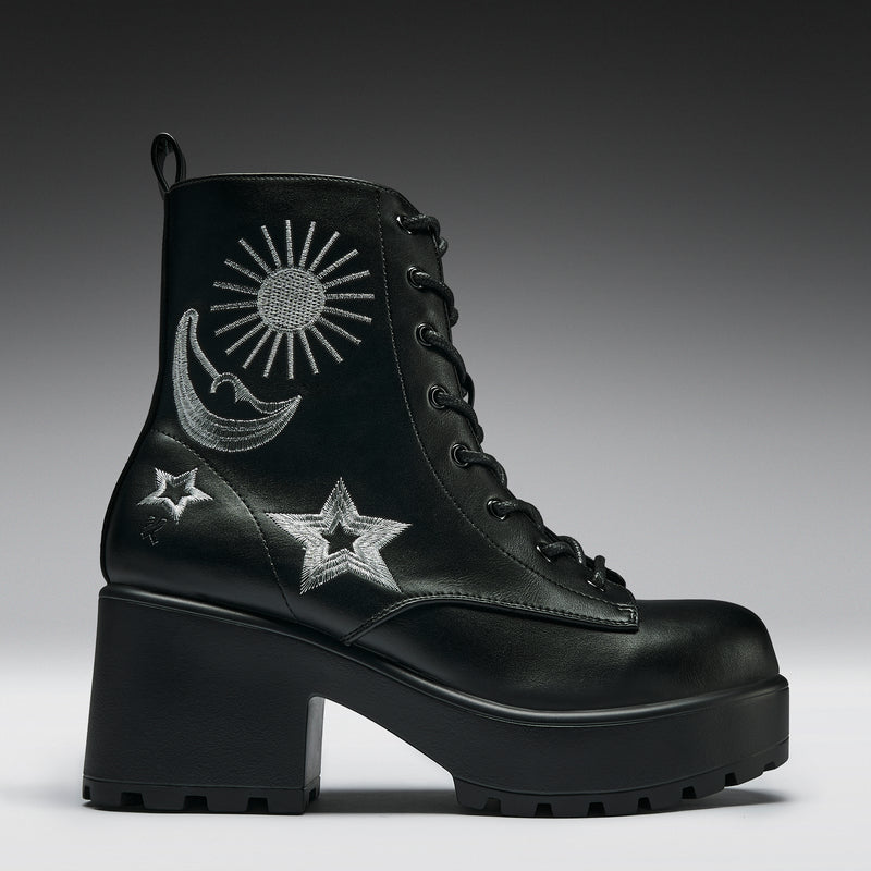 Black boot with embroidered designs on a gradient background