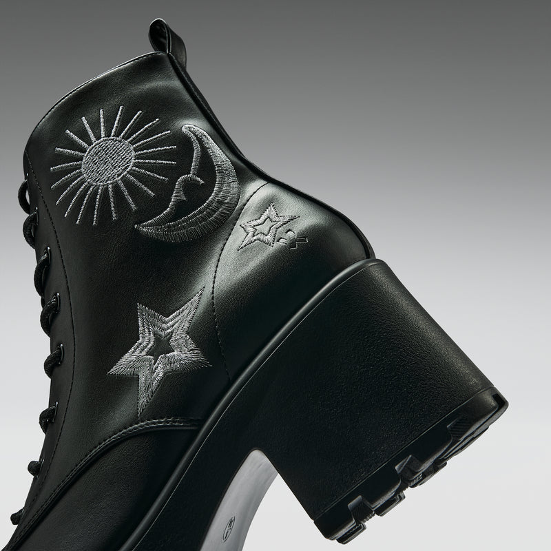 Black boot with embroidered designs on a gray background