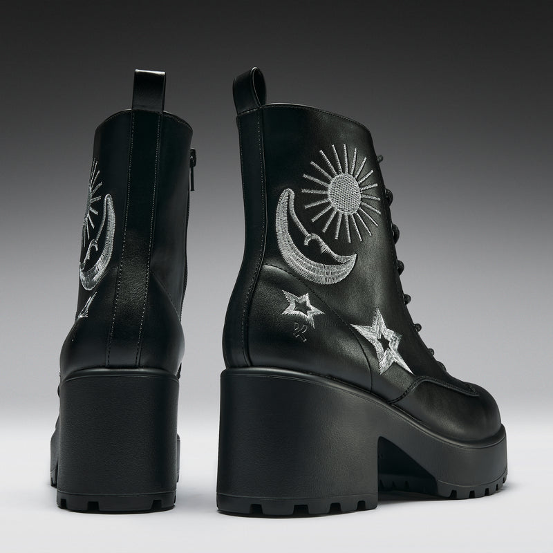 Black platform boots with celestial designs on a gradient background