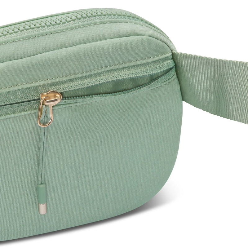 Close-up of light green Aura oval crossbody bag front seam and gold-tone ring