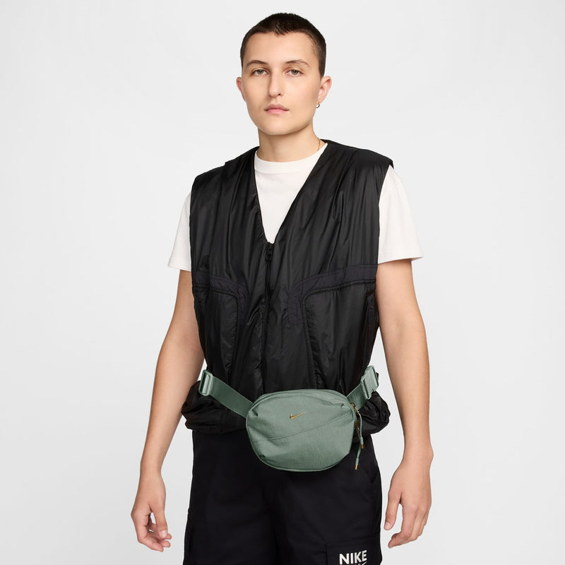 Light green Aura oval crossbody bag worn at hip, zip front and adjustable strap