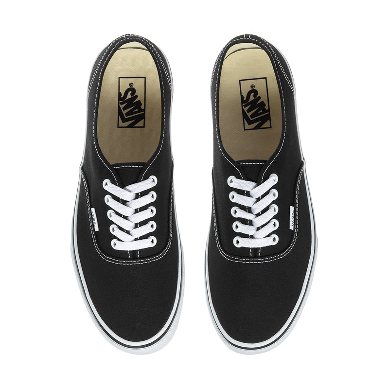 Men's black canvas sneakers, top view, white laces and Vans label on tongues