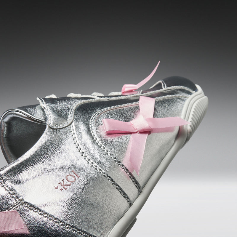 Silver sneaker with pink laces on a gradient background