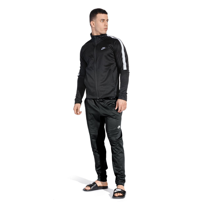 Men's black Nike slides worn with black tracksuit pants
