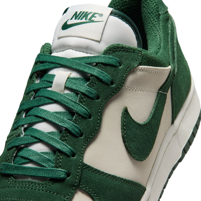 Close-up of men's Nike low-top sneakers laces, dark green suede upper and cream lining