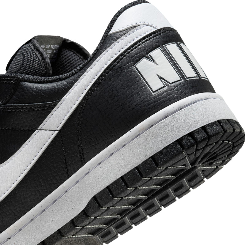 Close-up of men's black low-top sneaker side with white stripe and textured tread