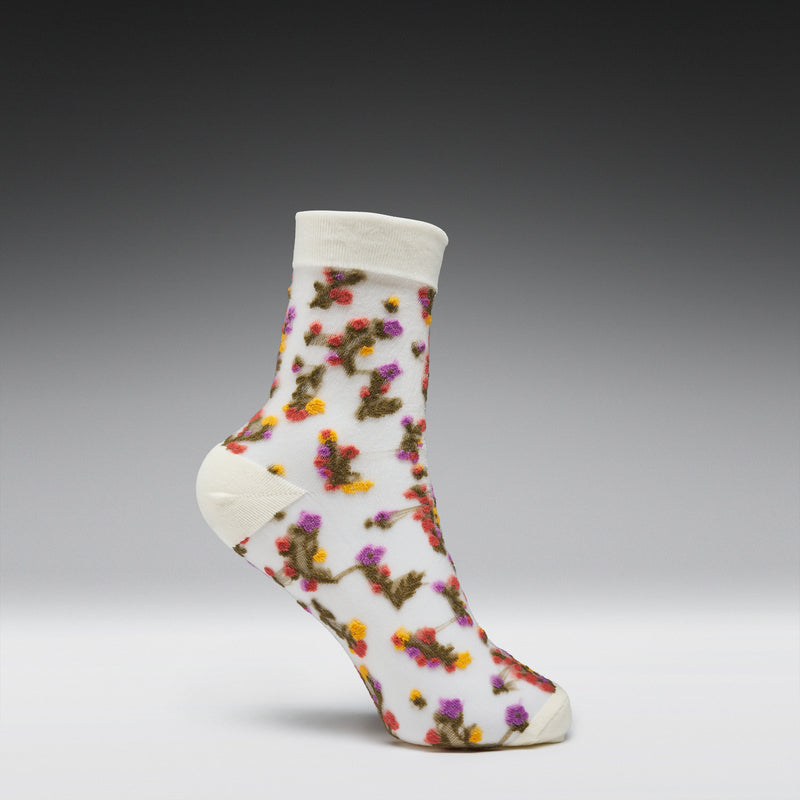 White sock with colorful floral pattern on a gray background
